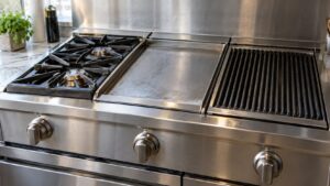 Close-up of a stainless steel DCS rangetop panel with three interchangeable cooking modules set side by side in their bays