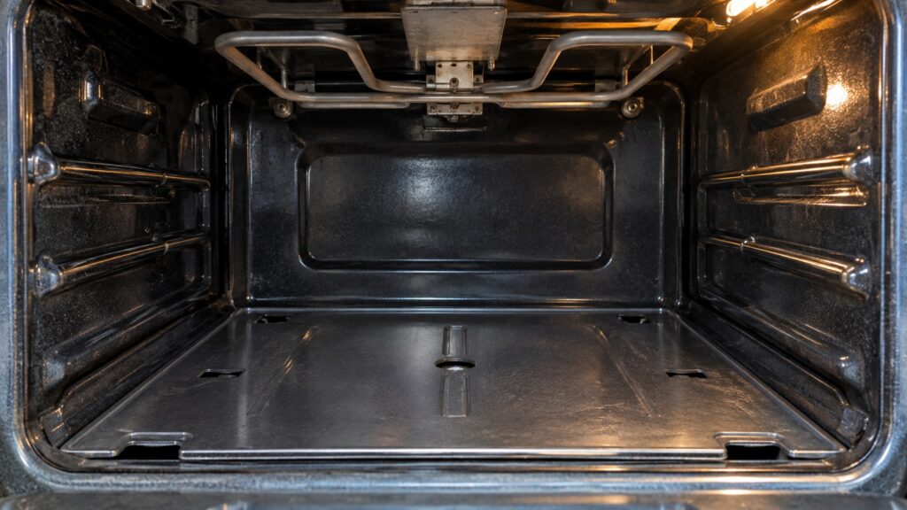 The bottom of an oven cavity showing the flat bake burner cover with the broil burner above