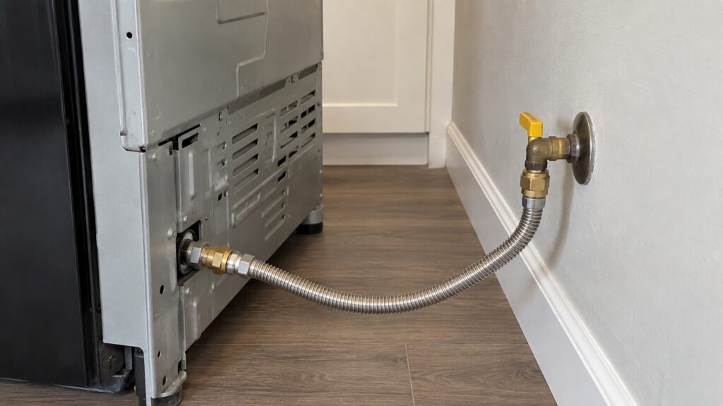 The back of a range with a flexible gas line connection and a shutoff valve at the wall